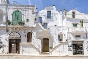 a group of white buildings with stairs in a street at Suite La Scala del Borgo in Cisternino