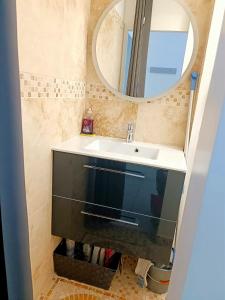 W łazience znajduje się umywalka i lustro. w obiekcie Bron centre appartement meublé avec jacuzzi w mieście Bron
