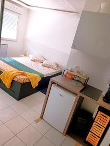 een kleine slaapkamer met een bed en een whiteboard erin bij Bron centre appartement meublé avec jacuzzi in Bron