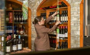 a woman is reaching for a bottle of wine at מול הכנרת Over looking the Sea of Galilee in Chorazim