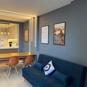 a living room with a blue couch and a table at Apartamento Vista.Rio in Niterói