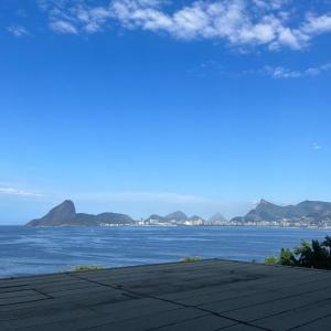 Apartamento Vista.Rio في نيتيروي: إطلالة على المحيط مع الجبال في المسافة