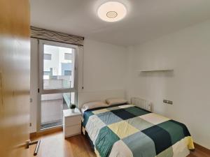 a bedroom with a bed and a window at Family apartment Forum in Barcelona