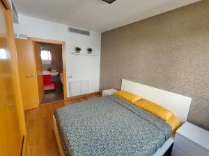 a bedroom with a bed with a yellow pillow on it at Family apartment Forum in Barcelona