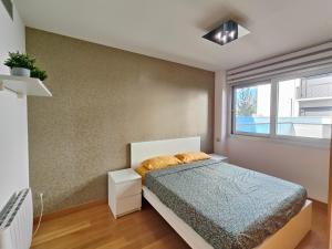 a bedroom with a bed and a window at Family apartment Forum in Barcelona