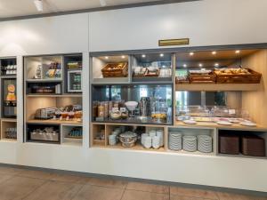 a bakery with a display case filled with food at B&B Hotel Mülheim an der Ruhr in Mülheim an der Ruhr