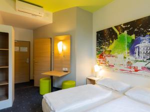 una camera d'albergo con letto e scrivania di B&B Hotel Mülheim an der Ruhr a Mülheim an der Ruhr