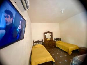 um quarto com 2 camas e uma televisão de ecrã plano em Casa Vergel Hotel Boutique em Lamadrid