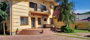 Casa amarilla con escaleras y balcón en VILLA VERA en Berehove