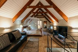 a living room with a bed and a tv at Silky Oaks Couples Retreat in Riebeek-Kasteel