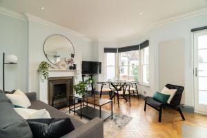 倫敦的住宿－Margravine Gardens by Viridian Apartments，客厅配有沙发和桌子