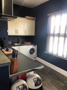 a kitchen with a washer and dryer on a counter at Raby Apartment in Darlington