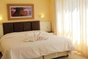 una camera da letto con un letto e due asciugamani di Kaaro Hotel El Buho a Puno