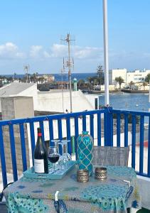 una mesa con una botella de vino y copas en La Buganvilla rooms en Arrecife