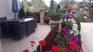 a garden with flowers and a table and a fence at Apartment Niva in Zlatibor