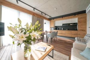 a living room with a vase of flowers on a table at Rezydencja OWCA NA SZLAKU in Zakopane