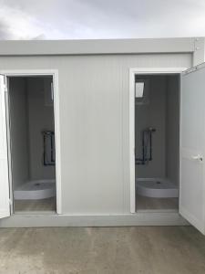 a white room with two sinks and two toilets at Agri Camping italiano - Eucalyptus in Shënkoll
