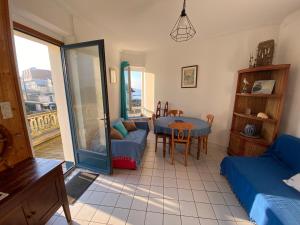 a living room with a couch and a table at Le Chalet Théodore - Le 3bis in Wimereux