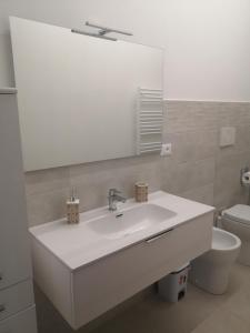 bagno con lavandino, specchio e servizi igienici di A Casa di Amici ad Arezzo