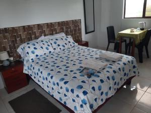 een slaapkamer met een bed met een blauw en wit dekbed bij My House in Puerto Villamil