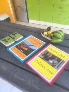 een bos boeken op een toonbank met een kom fruit bij Gite à 2 pas de la flamboyante plage de La Perle in Deshaies