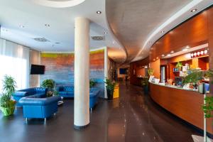 eine Lobby eines Hotels mit blauen Sofas und Pflanzen in der Unterkunft Concordia Hotel in San Possidonio