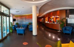 eine Lobby mit blauen Stühlen und einer Bar in der Unterkunft Concordia Hotel in San Possidonio
