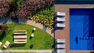 ブエノスアイレスにあるFliphaus Be Libertador - Lux 3 Pax Loft 10-3のスイミングプールと椅子、庭園の景色を望めます。