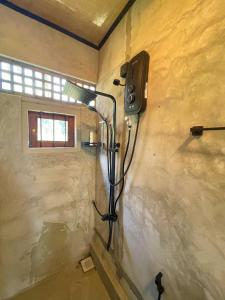 y baño con ducha y pared. en Amandawa Eco, en Gampaha