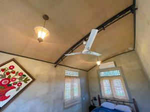 1 dormitorio con ventilador de techo y 2 ventanas en Amandawa Eco, en Gampaha