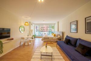 Fliphaus Be Libertador - Lux 3 Pax Loft 10-3 في بوينس آيرس: غرفة معيشة مع أريكة زرقاء وطاولة