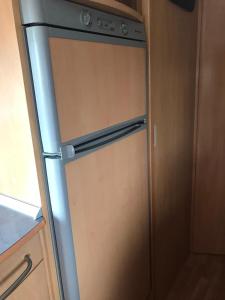 a stainless steel refrigerator in a kitchen at Agri Camping italiano - Eucalyptus in Shënkoll