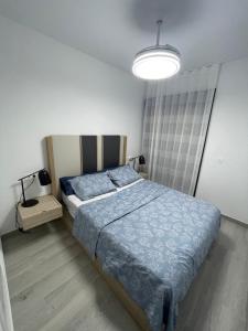 a bedroom with a bed with a blue comforter and a lamp at Mar Menor Elisa Apartment in Santiago de la Ribera +38 photos