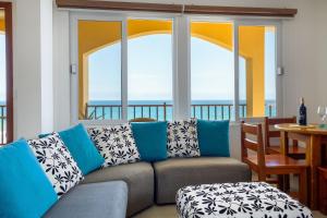 a living room with a couch and a table and windows at Beso del Sol in Santa Marianita