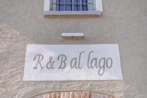 una señal en el lado de un edificio que lee riel labagna en R&B al lago, en Domaso