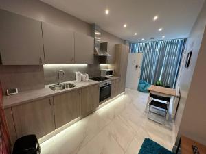 ロンドンにあるThemed Stunning 1-Bed Apartment in Londonのキッチン(木製キャビネット、シンク、テーブル付)