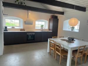 a kitchen and dining room with a table and chairs at Lilla Stenhuset in Ystad