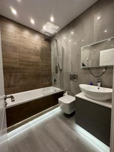a bathroom with a tub and a sink and a toilet at Themed Stunning 1-Bed Apartment in London in London