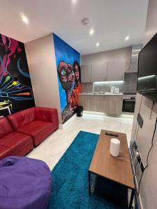 ロンドンにあるThemed Stunning 1-Bed Apartment in Londonのリビングルーム(赤いソファ付)、キッチン