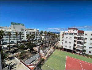 a tennis court in the middle of a city with buildings at Apartamento céntrico de estilo nórdico in Adeje