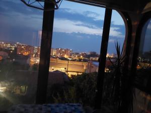 - une vue sur la ville la nuit depuis une fenêtre dans l'établissement Apartman - Jaksa, à Bar