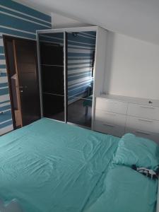 - une chambre avec un lit vert et un miroir dans l'établissement Apartman - Jaksa, à Bar
