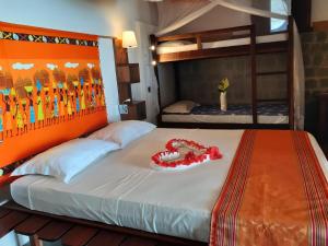 a bedroom with a large bed with an orange headboard at Libertalia Hotel in Sainte Marie