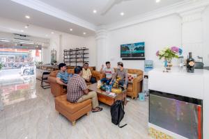 un grupo de personas sentadas en una sala de estar en Ha Vy Hotel, en Ho Chi Minh