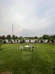 イスラマバードにあるDHA 2 Islamabadの草原の椅子2脚とテーブル