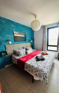 a bedroom with a bed with a blue wall at Apartamento BLUE OCEAN Complex Amaya Fuerteventura in Costa de Antigua