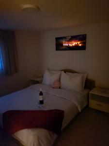 1 dormitorio con 1 botella de vino en la cama en Vikendica za odmor, en Banja Luka