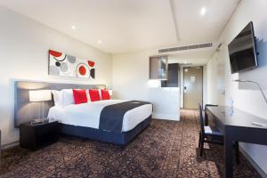 a hotel room with a large bed and a desk at Calamvale Hotel Suites and Conference Centre in Brisbane +83 photos