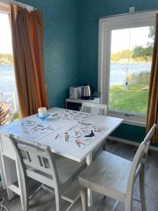 Guest house at Baltic Sea Oskarshamn في أوسكارسهامن: طاولة بيضاء وكراسي في غرفة مع نافذة