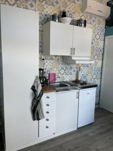 a kitchen with white cabinets and a counter top at Guest house at Baltic Sea Oskarshamn in Oskarshamn